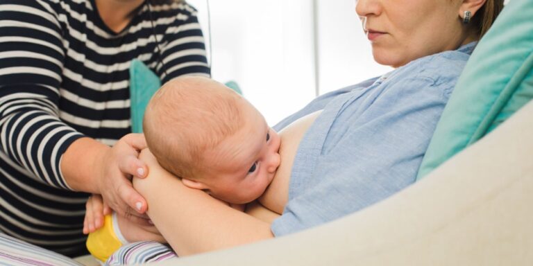 lactation consultant helping mother breastfeed