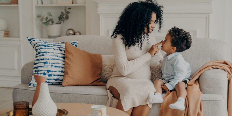 pregnant mom and son sitting on the sofa talking